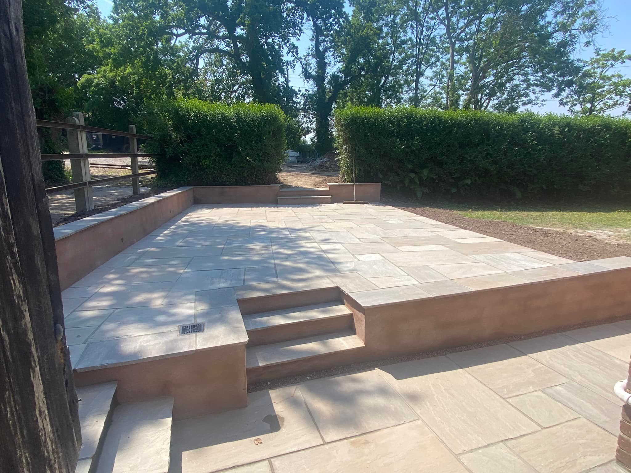 Tiered porcelain patio with rendered walls in a rural setting